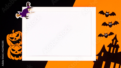 Halloween background with copy space in frame and scary stickers on orange and black background. Flat lay