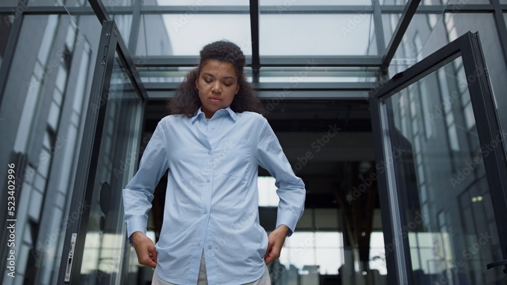 Stressed office worker looking down feeling bored contemporary office building. Stressed office worker looking down feeling bored contemporary office building.