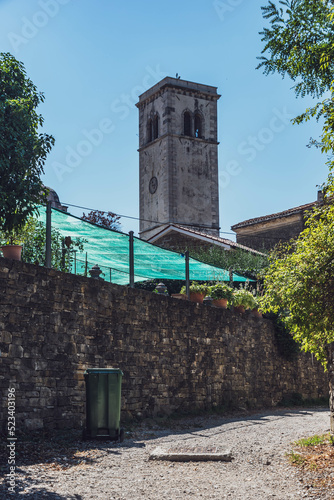 alley and church tower in the old town of oprtalj, croatia photo