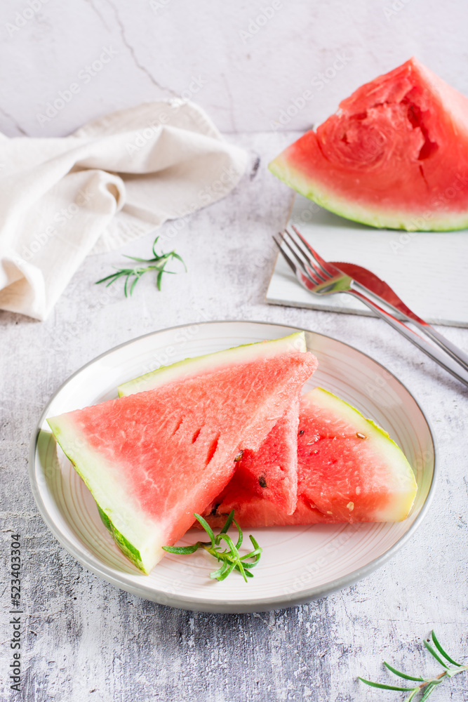 Pieces of fresh juicy watermelon on a plate on the table. Summer refreshment. Vertical view Pieces of fresh juicy watermelon on a plate on the table. Summer refreshment. Vertical view