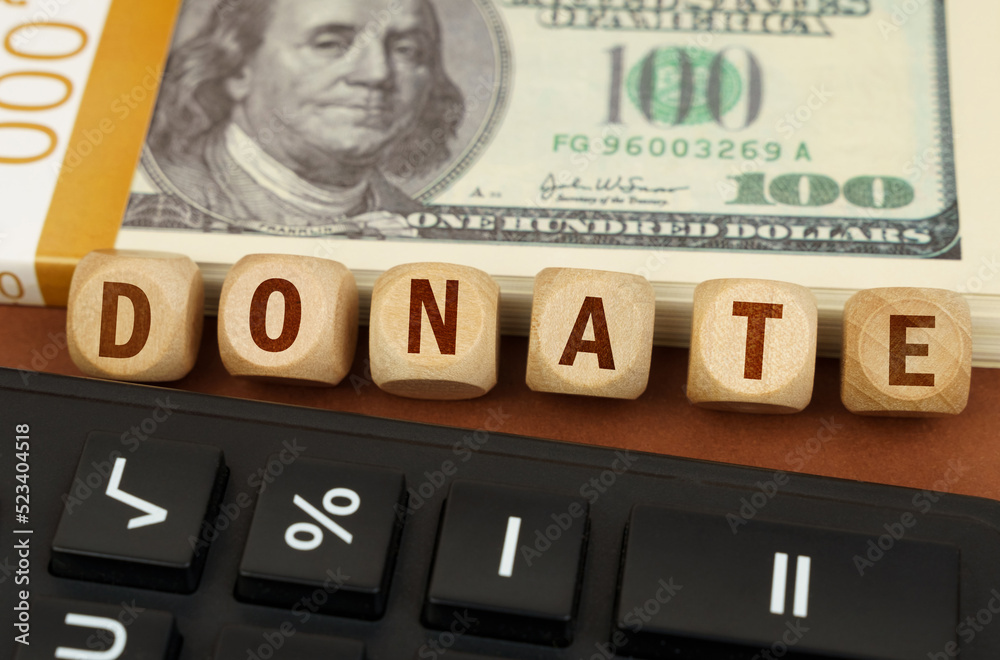Next to the calculator and dollars are cubes with the inscription - DONATE Next to the calculator and dollars are cubes with the inscription - DONATE