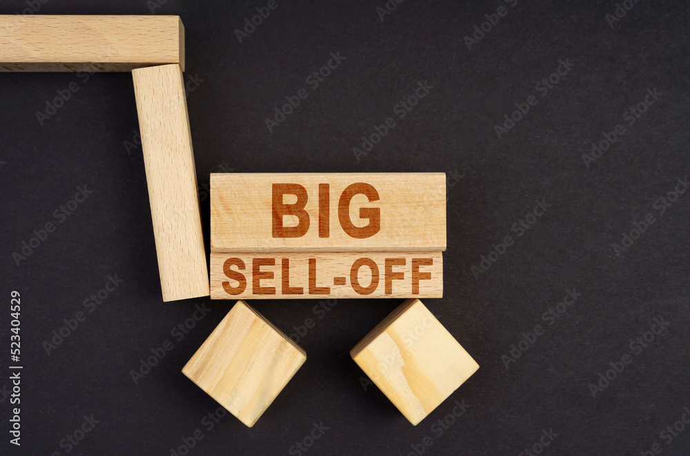 On a black surface, a cart made of blocks and cubes with the inscription - Big Sell-Off On a black surface, a cart made of blocks and cubes with the inscription - Big Sell-Off