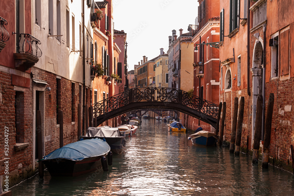 The old bridge made with decorated iron on the typical canal in Venice