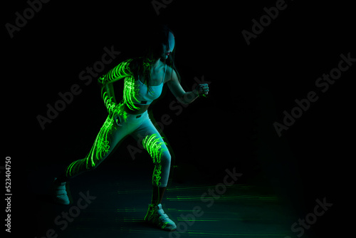 Woman in futuristic costume. Female posing in glasses of virtual reality. Augmented reality game, future technology, AI concept. VR. Neon blue light.