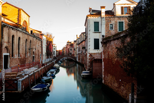The old bridge made with red bricks on the typical canal in Venice © bepsphoto
