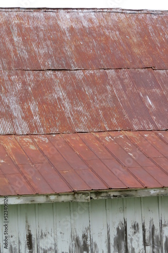 distressed red tin roof of white washed building