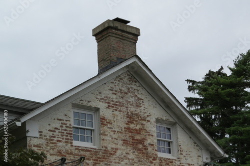 white washed brick building with chimney and two windows