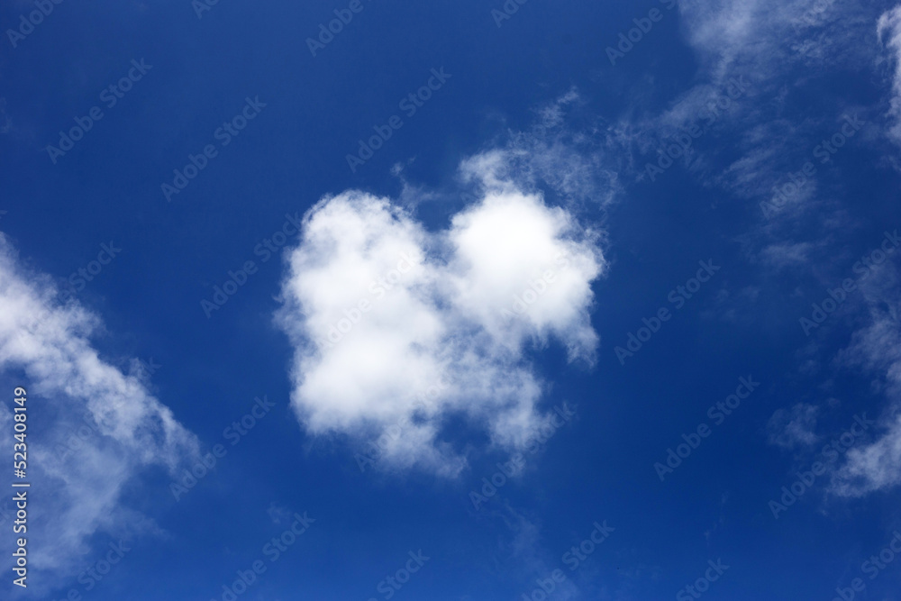 Fototapeta premium Blue sky background with cloud. Heart shape