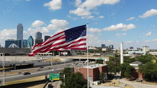 Dallas, TX USA - August 14, 2022: Aerial closeup of American flag waving over downtown Dallas skyline. photo