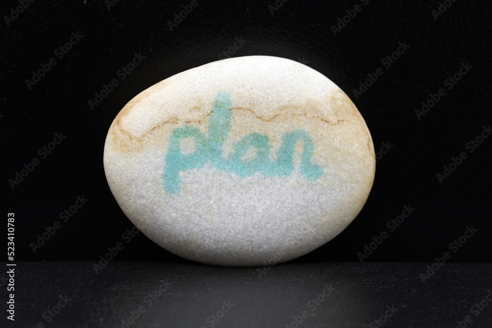 detalle de una piedra con la palabra escrita, plan, sobre fondo negro detalle de una piedra con la palabra escrita, plan, sobre fondo negro