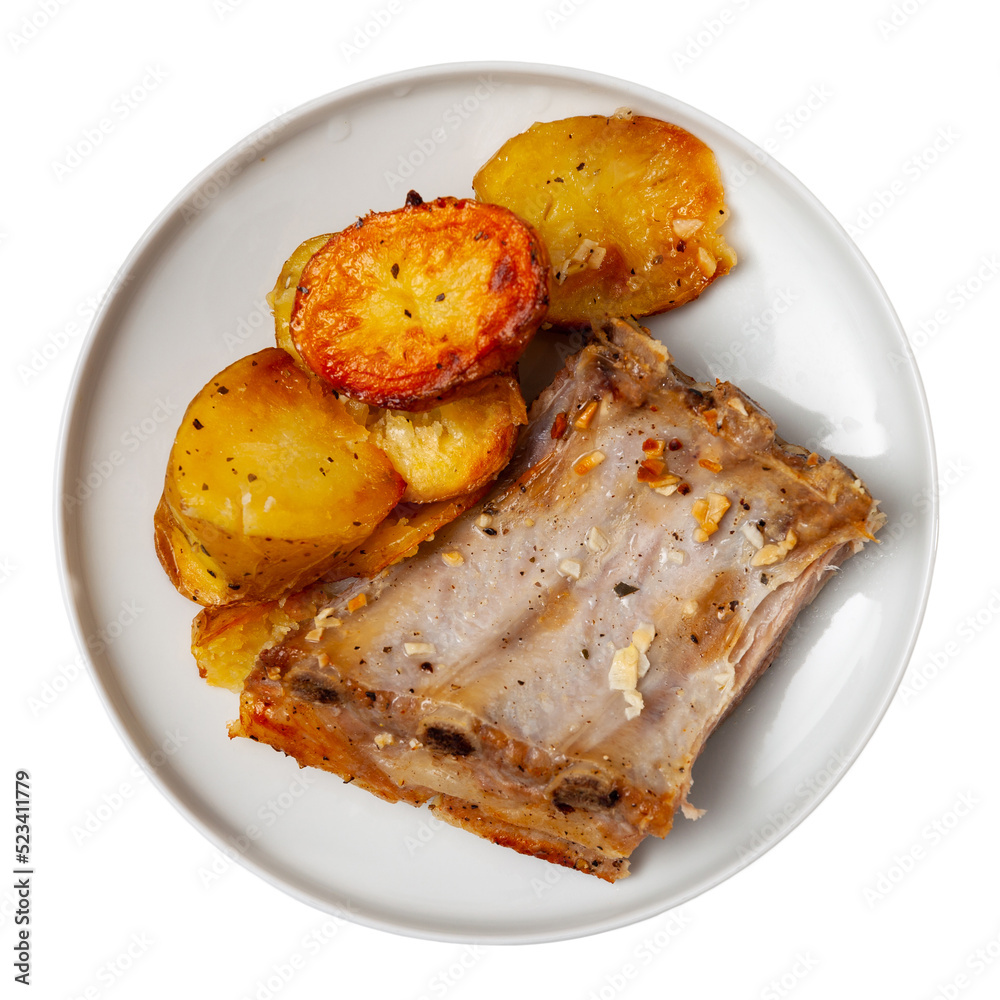 Pork ribs with boiled potatoes and spices on a ceramic plate. Isolated over white background