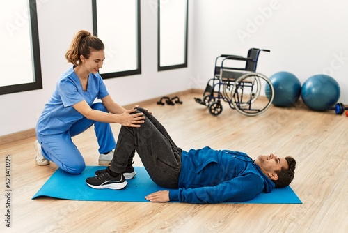 Young disabled man making mobility exercise at the clinic.