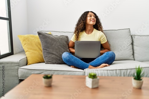 Young latin woman smiling confident using laptop at home