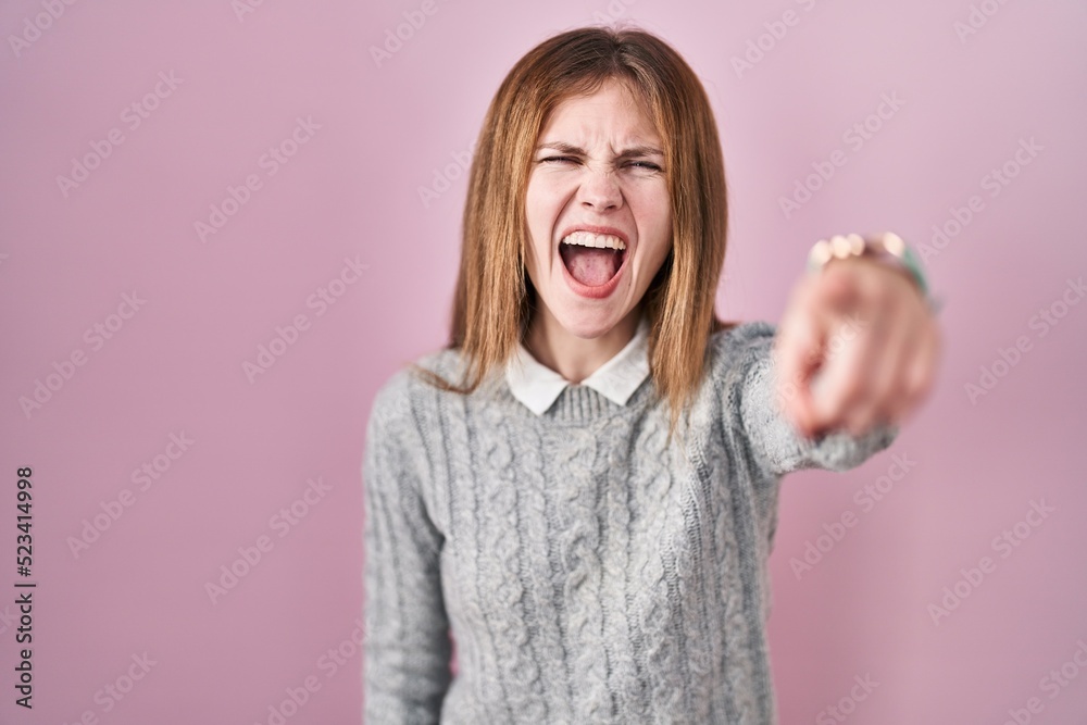 Beautiful woman standing over pink background pointing displeased and frustrated to the camera, angry and furious with you Beautiful woman standing over pink background pointing displeased and frustrated to the camera, angry and furious with you