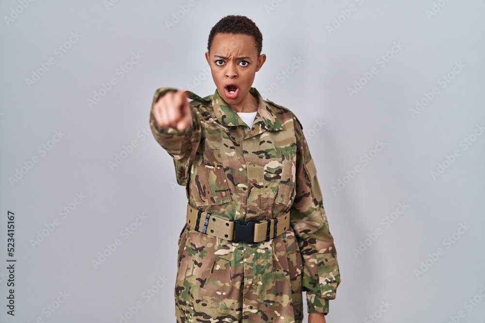 Beautiful african american woman wearing camouflage army uniform pointing displeased and frustrated to the camera, angry and furious with you