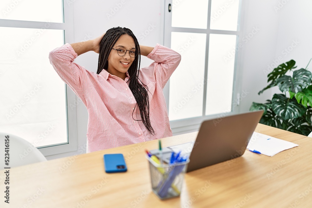 Young african american woman relaxed with hands on head working at office Young african american woman relaxed with hands on head working at office