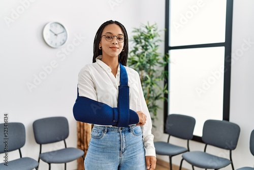 Young african american woman smiling confident injury on arm at clinic waiting room © Krakenimages.com