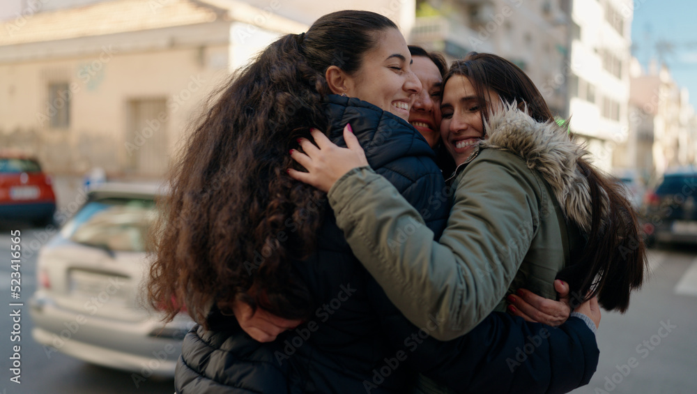Mother and daugthers smiling confident hugging each other at street Mother and daugthers smiling confident hugging each other at street