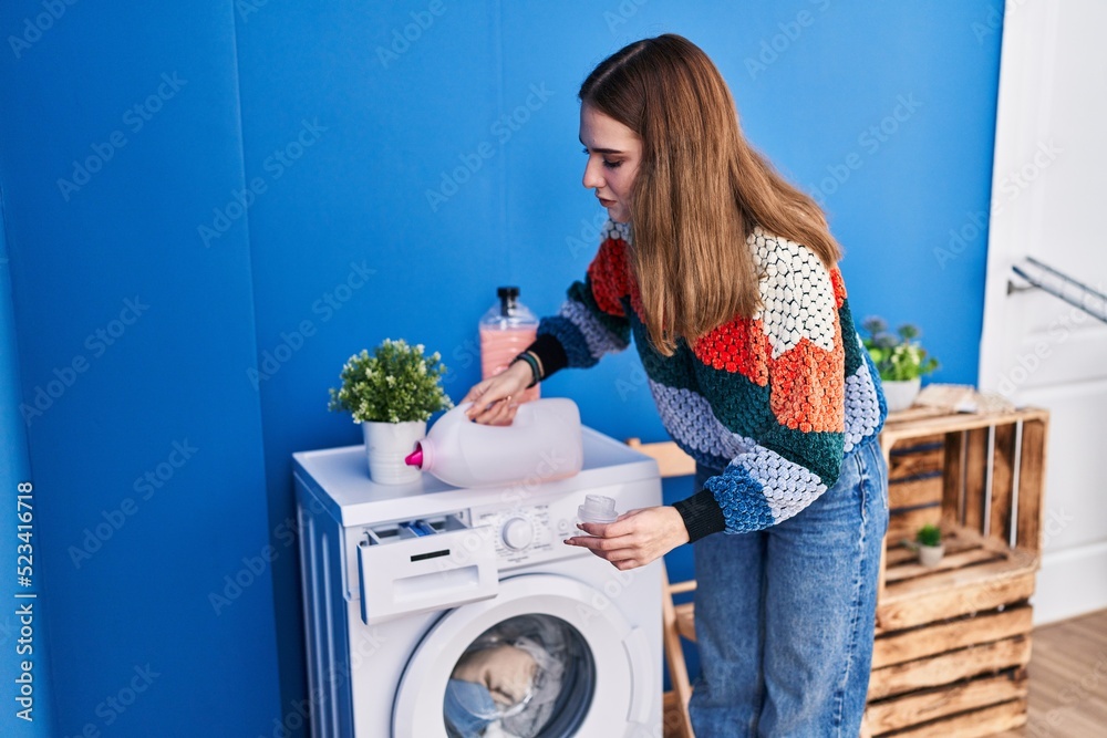 Young woman smiling confident pouring detergent on washing machine at laundry room Young woman smiling confident pouring detergent on washing machine at laundry room