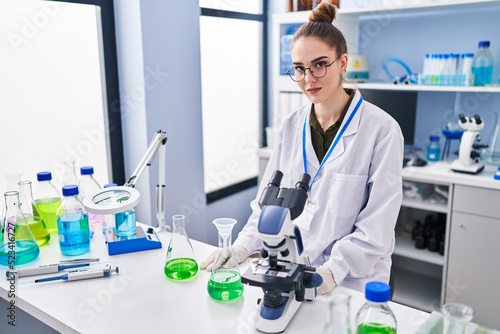 Young woman scientist smiling confident at laboratory