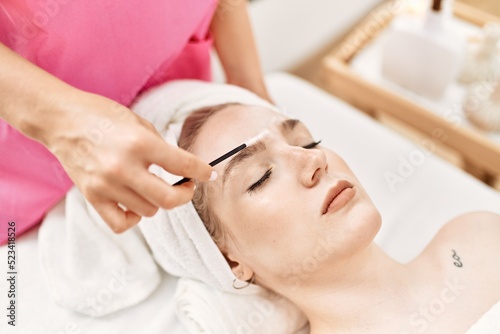 Woman reciving eyebrows treatment at beauty center.