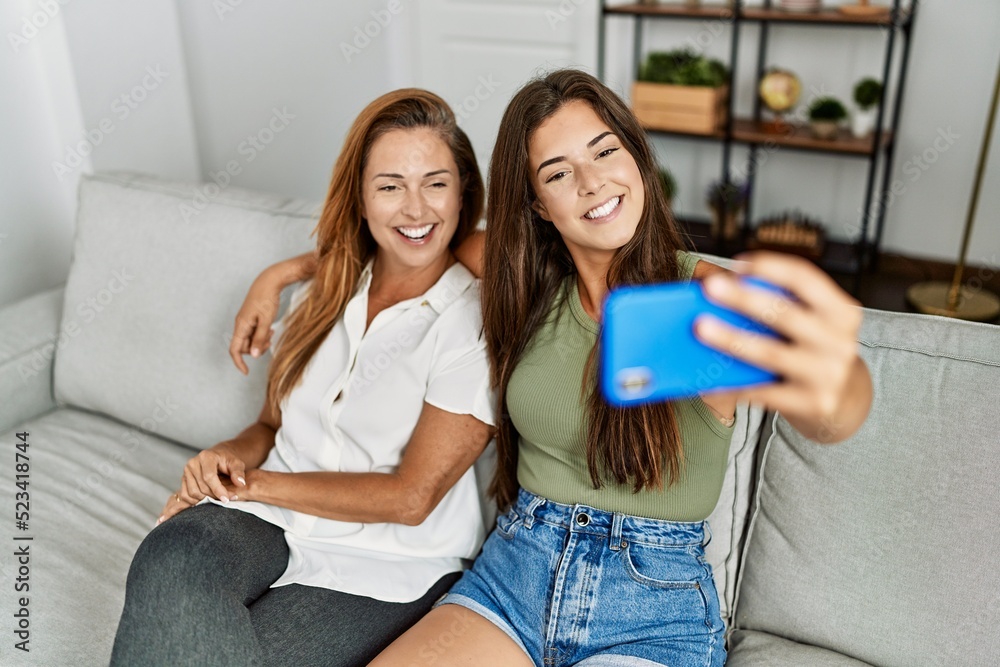Mother and daughter smiling confident and hugging each other making selfie by the smartphone at home Mother and daughter smiling confident and hugging each other making selfie by the smartphone at home