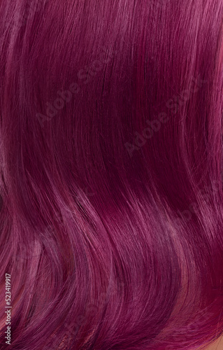 A closeup view of a bunch of shiny straight purple hair in a wavy curved style