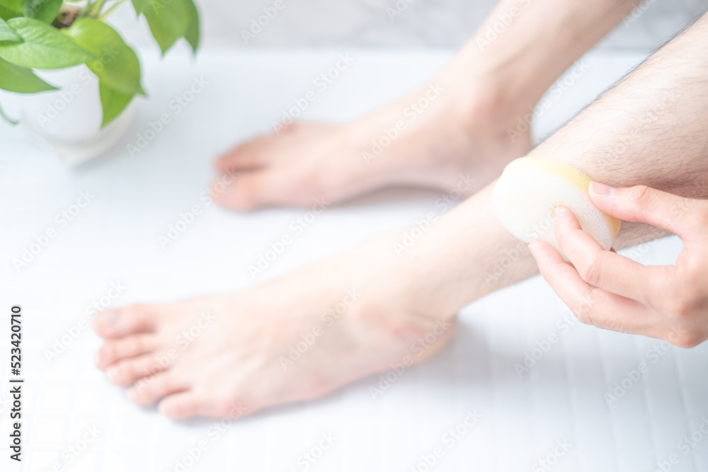 Fototapeta premium 除毛クリームを使う男性の脚