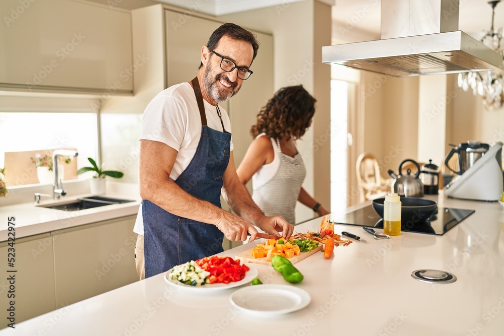 Middle age hispanic couple smiling confident cooking at kitchen Middle age hispanic couple smiling confident cooking at kitchen