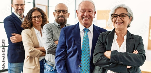 Group of middle age business workers smiling happy standing with arms crossed gesture at the office