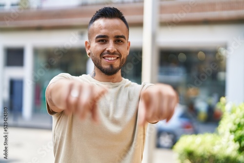 Young hispanic man smiling confident pointing with fingers at street © Krakenimages.com