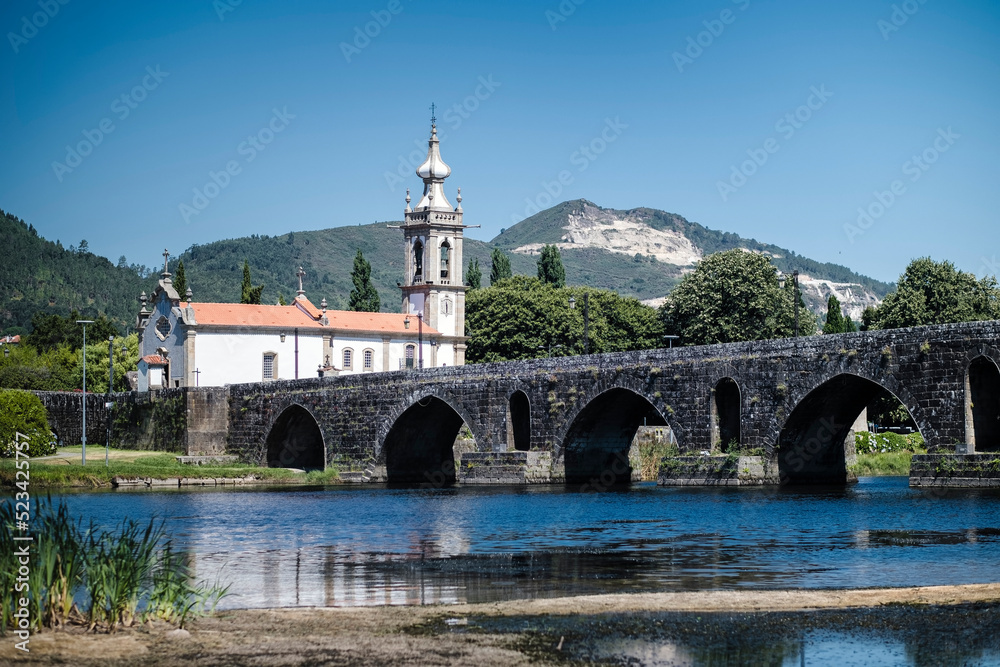 View of a long medieval bridge, over the Lima River, in Ponte de Lima, Portugal.