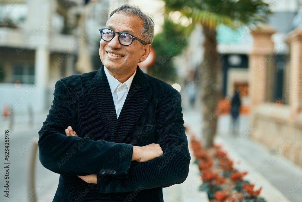 Middle age southeast asian man smiling confident with crossed arms at the city Middle age southeast asian man smiling confident with crossed arms at the city