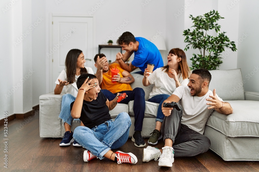 Group of young friends smiling happy playing video game at home. Group of young friends smiling happy playing video game at home.