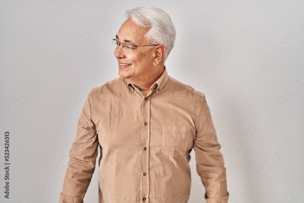 Hispanic senior man wearing glasses looking away to side with smile on face, natural expression. laughing confident. Hispanic senior man wearing glasses looking away to side with smile on face, natural expression. laughing confident.