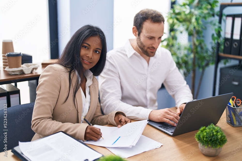 Man and woman business workers using laptop writing report at office Man and woman business workers using laptop writing report at office