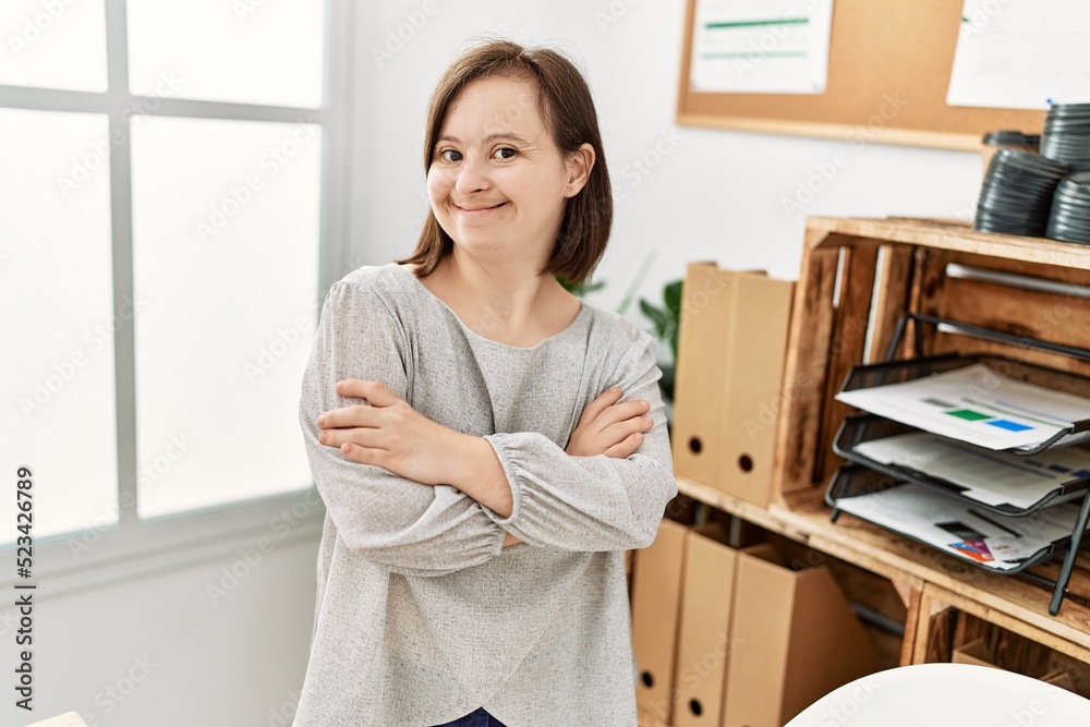 Brunette woman with down syndrome working standing with crossed arms at business office Brunette woman with down syndrome working standing with crossed arms at business office