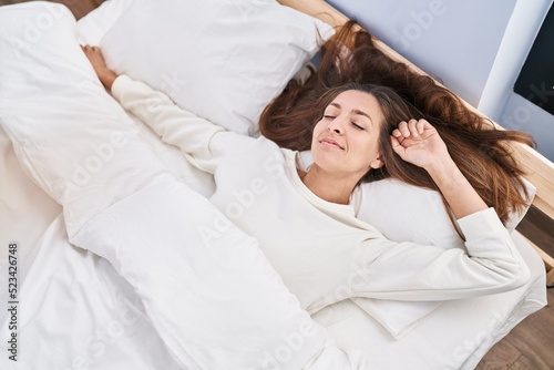 Young woman lying on bed sleeping at bedroom