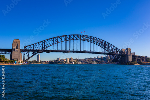 朝のオーストラリア・シドニーで、オペラハウス近くから見たハーバーブリッジ周辺の風景と青空 © 和紀 神谷