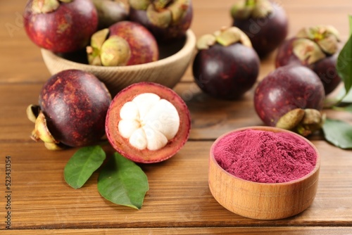 Purple mangosteen powder and fruits on wooden table