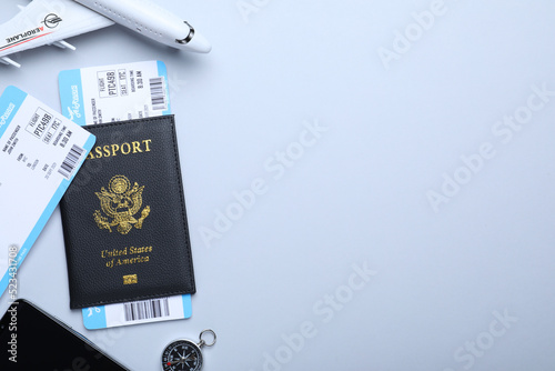 Flat lay composition with tickets and passport on white background, space for text. Travel agency concept