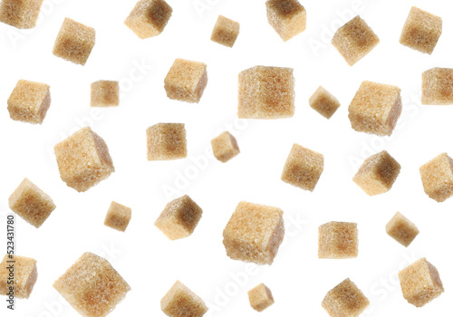 Flying cubes of brown sugar on white background