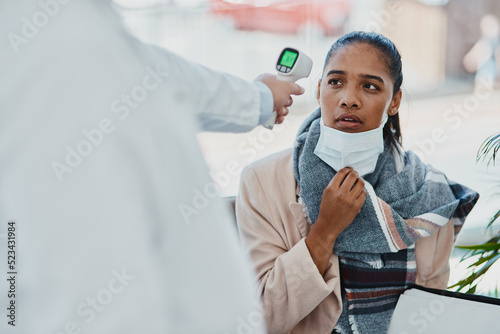 Covid temperature scanning a woman head at the border or an airport with real scared, concerned and serious expression on her face. Traveling refugee or foreign lady with a face mask in quarantine photo