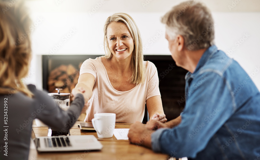 Financial advisor shaking hands with a female client after helping with budget, making a deal and planning with documents at home. Husband and wife paying for insurance and meeting with a consultant Financial advisor shaking hands with a female client after helping with budget, making a deal and planning with documents at home. Husband and wife paying for insurance and meeting with a consultant