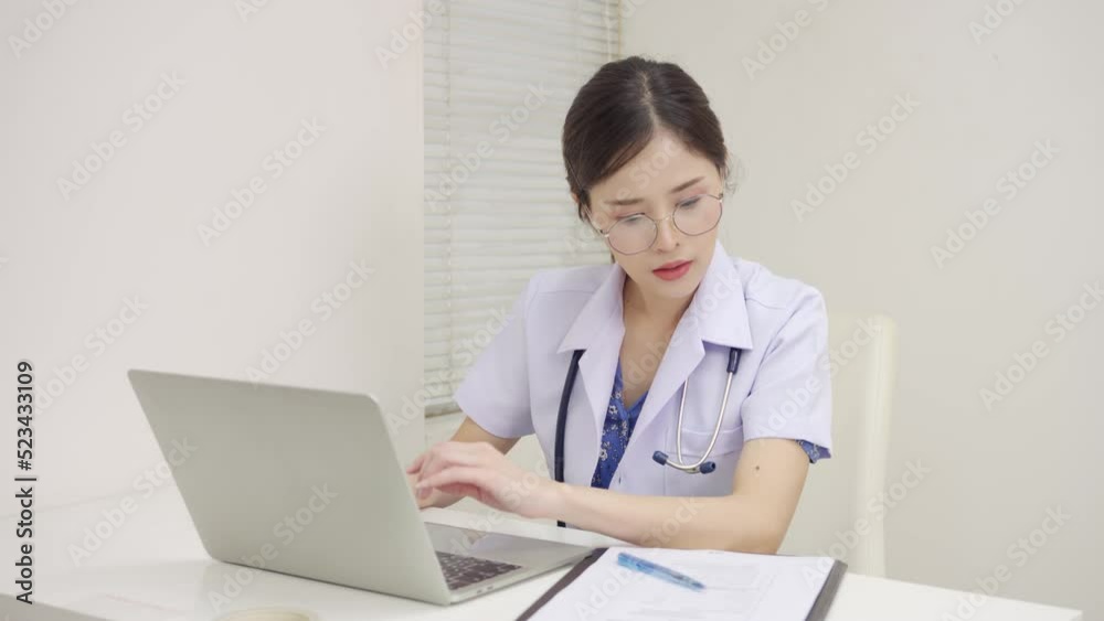 Asian female doctor using laptop answer questions from patients at home. Distant communication, health protection, and telemedicine concept Asian female doctor using laptop answer questions from patients at home. Distant communication, health protection, and telemedicine concept