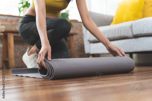 Fotografia sporty young woman prepare yoga mat to exercise  at home