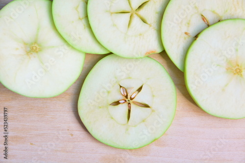 Heap of cutting into thin slices apples for cooking and preparing close up on wooden board. Top view, flat lay