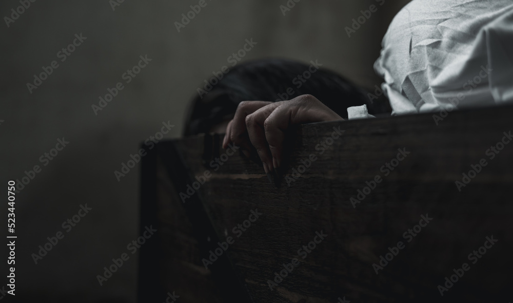 Horror ghost woman. Asian ghost horror creepy scary have hair covering face and eye lying in the old treasure chest, female makeup terror zombie face, murder, Closeup hand, Happy Halloween day concept Horror ghost woman. Asian ghost horror creepy scary have hair covering face and eye lying in the old treasure chest, female makeup terror zombie face, murder, Closeup hand, Happy Halloween day concept