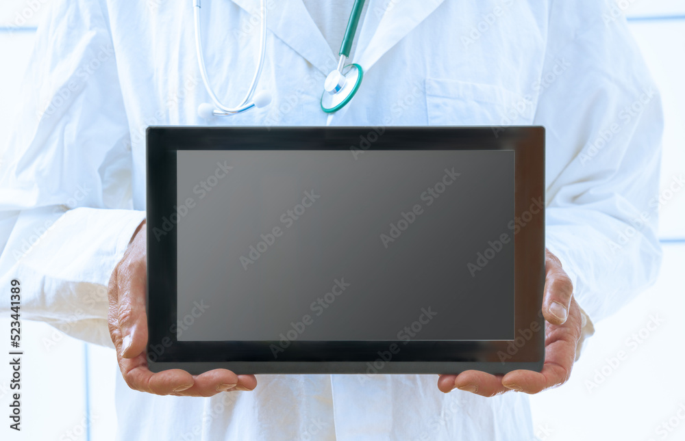 doctor with a stethoscope holds a tablet in his hands with an empty space. For text doctor with a stethoscope holds a tablet in his hands with an empty space. For text