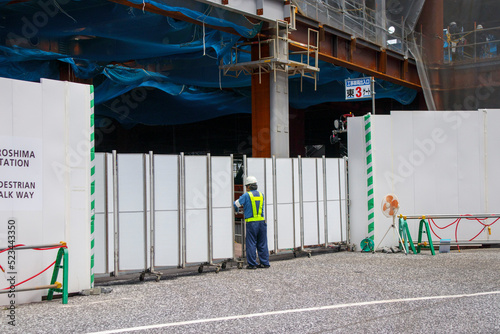 建設現場の防護柵の中を覗く人（仮囲い・工事用フェンス）